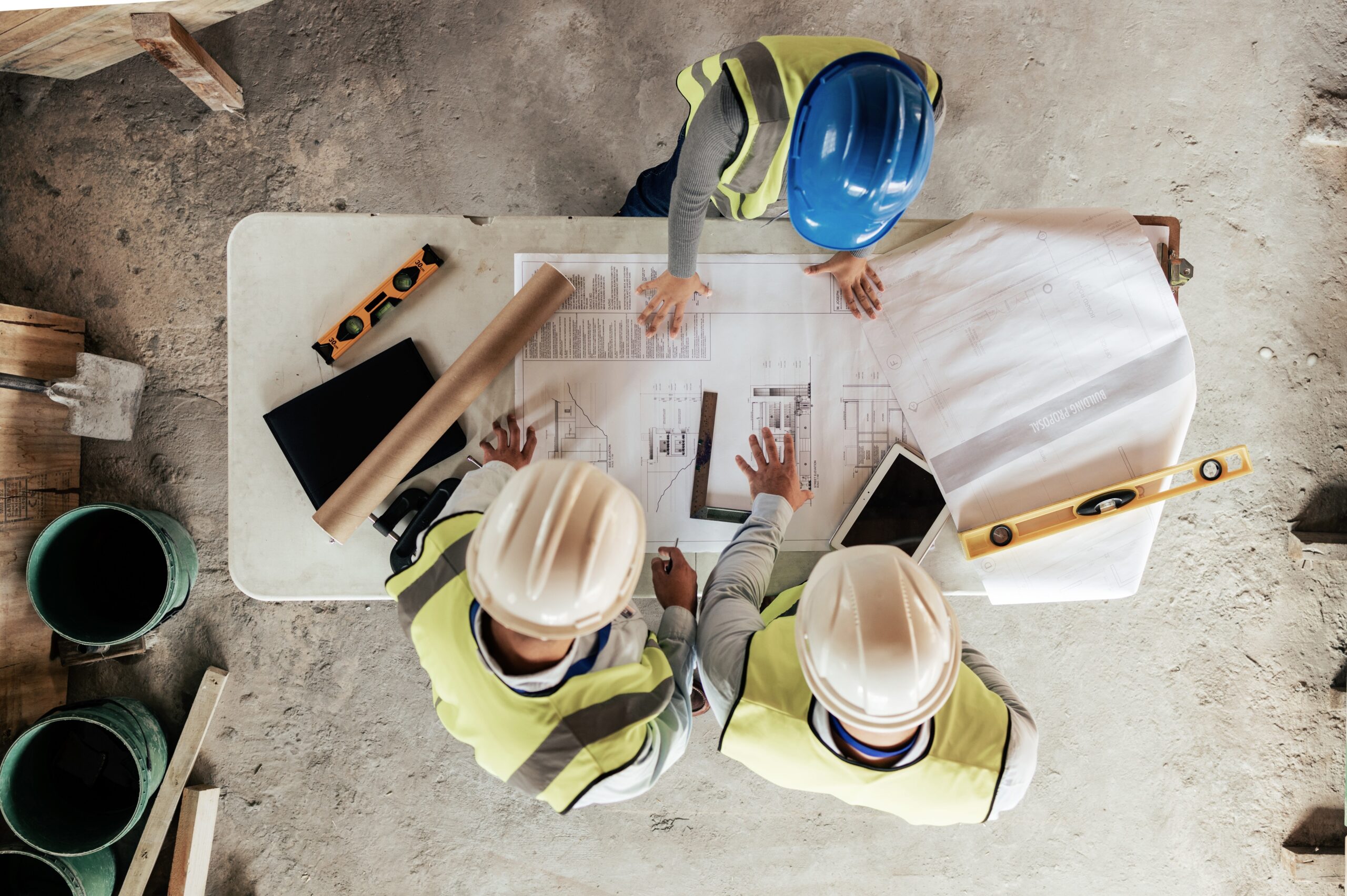 Architect, construction and blueprint with an engineer and designer team working on a building site from above. Meeting, planning and architecture with a design group in collaboration on a project.
